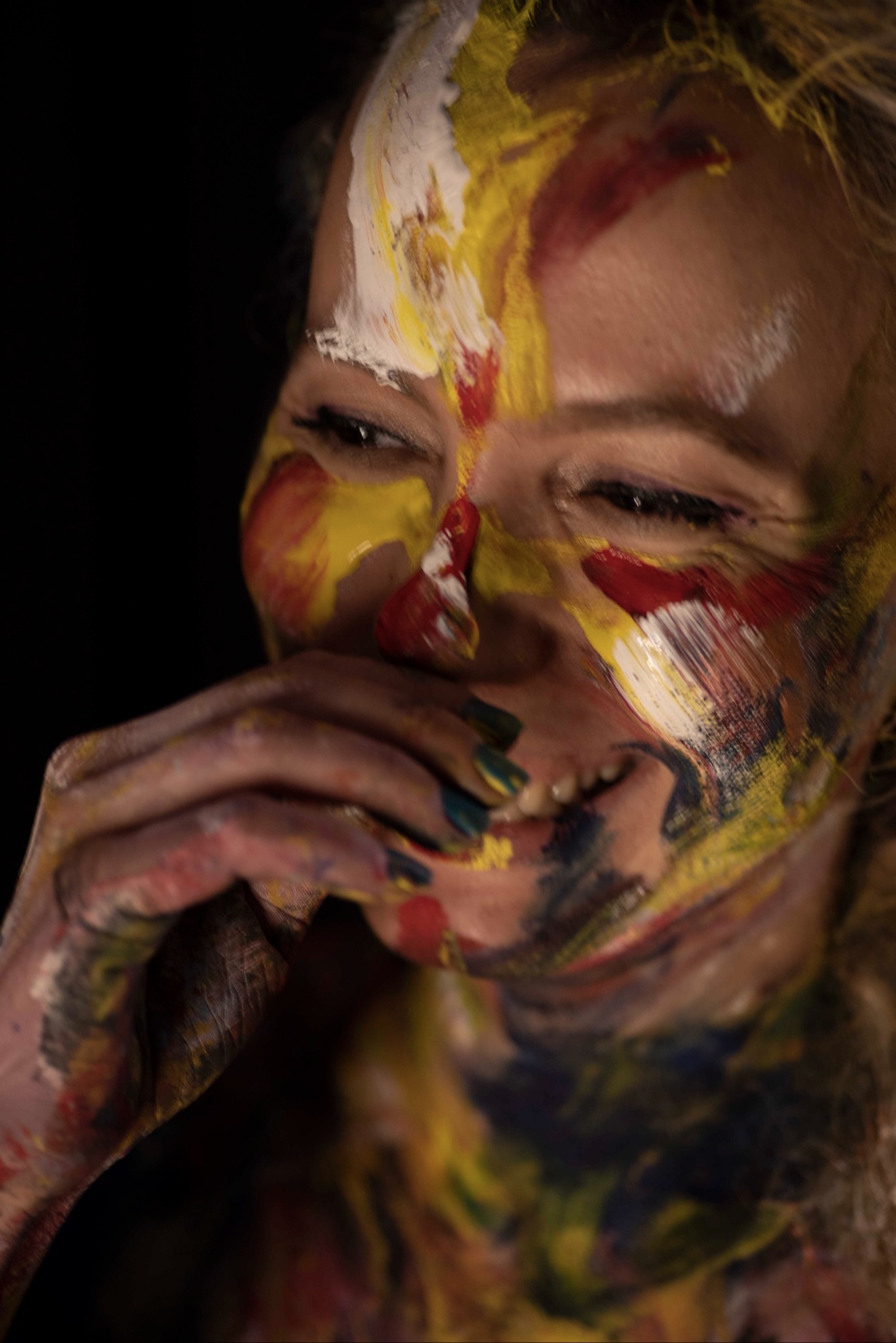 Laughing woman with colorful paint on her face